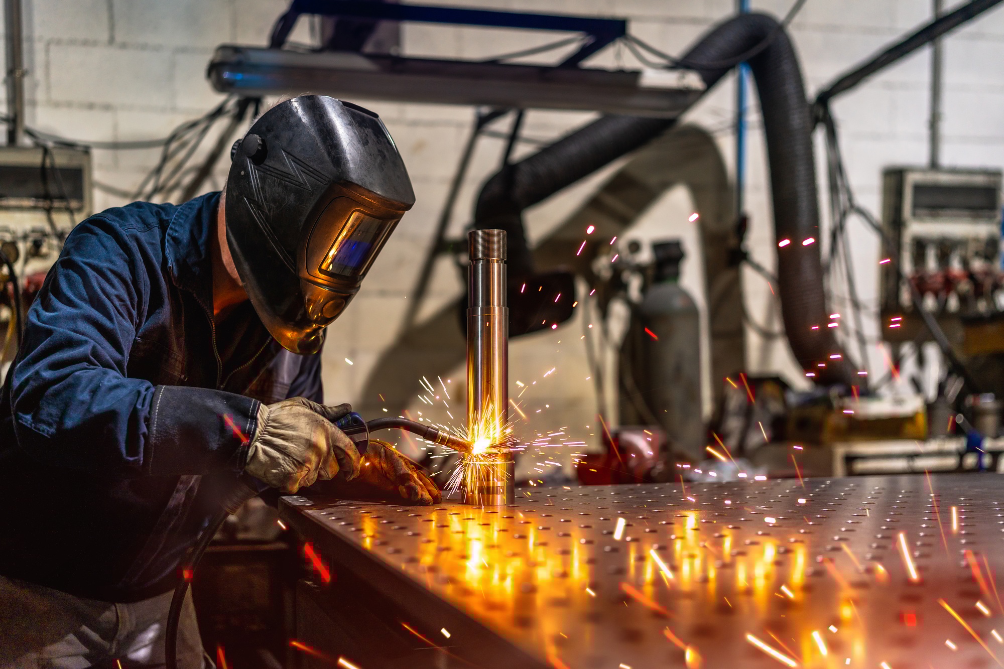 Welder welding a piece of metal in a factory